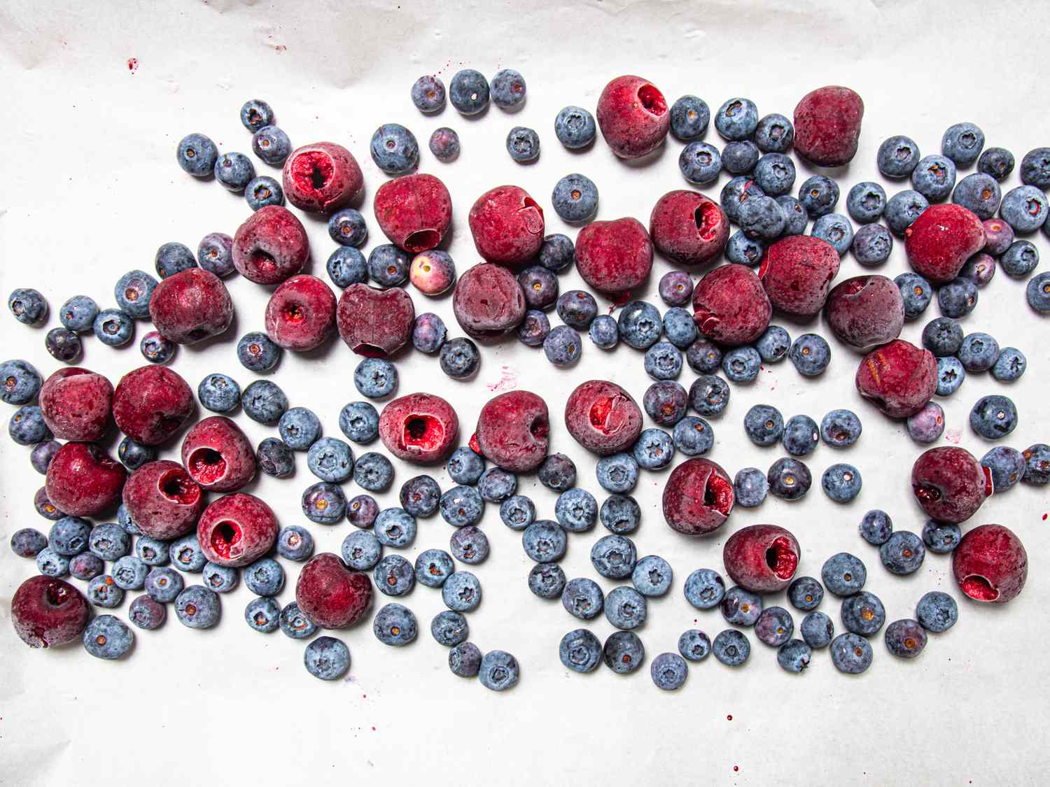 Frozen blueberries and raspberries spread on a surface