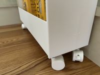 A closeup of the wheels of a white kitchen storage rack