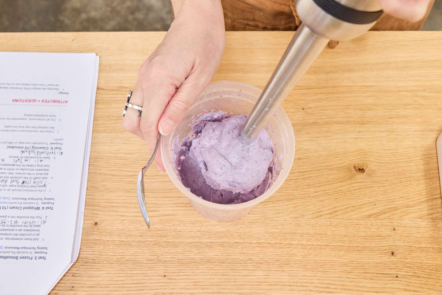 A person uses an All-Clad Stainless Steel Immersion Blender to make whipped cream.