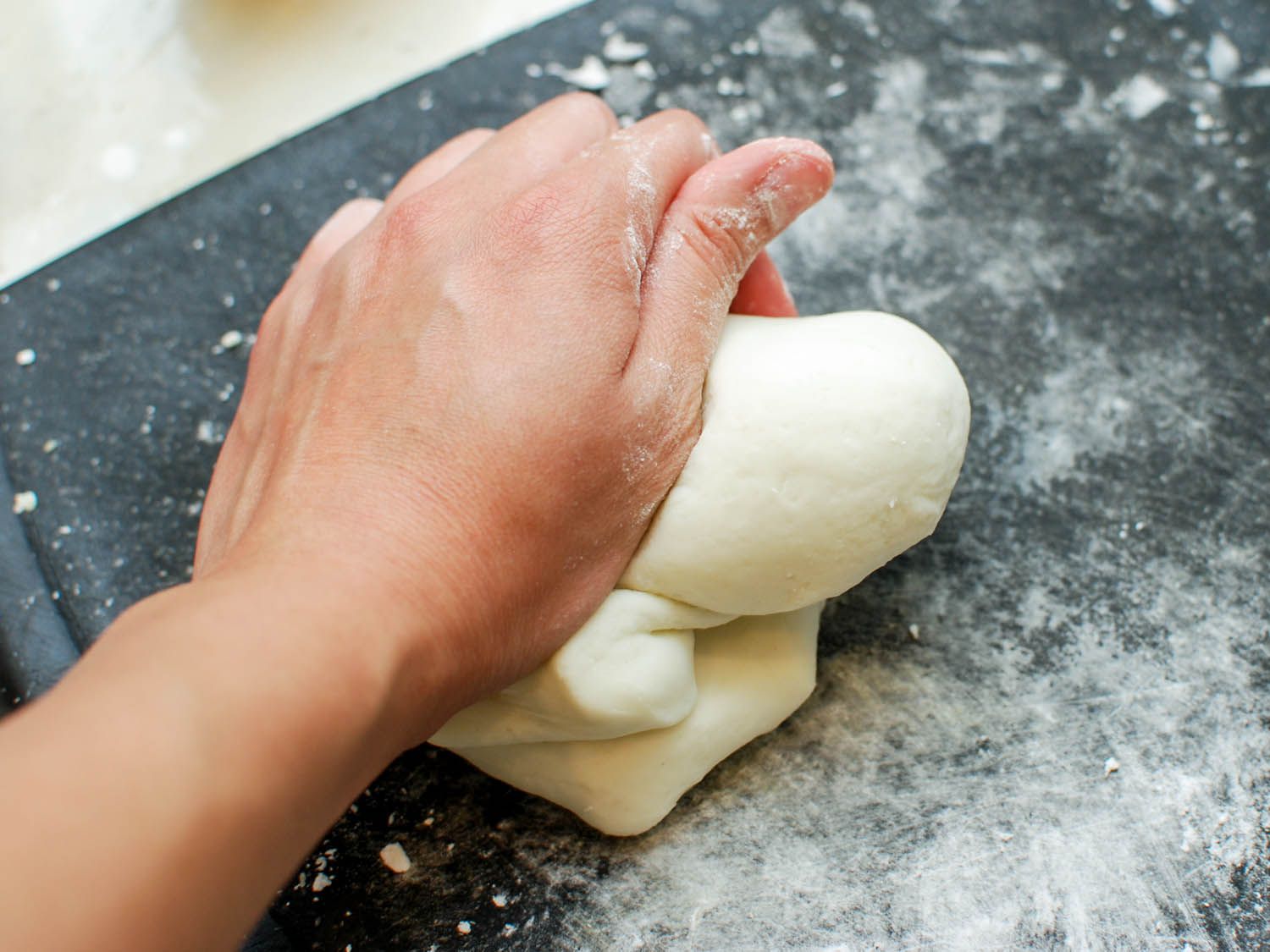 Author kneading dumpling dough on a floured cutting board.