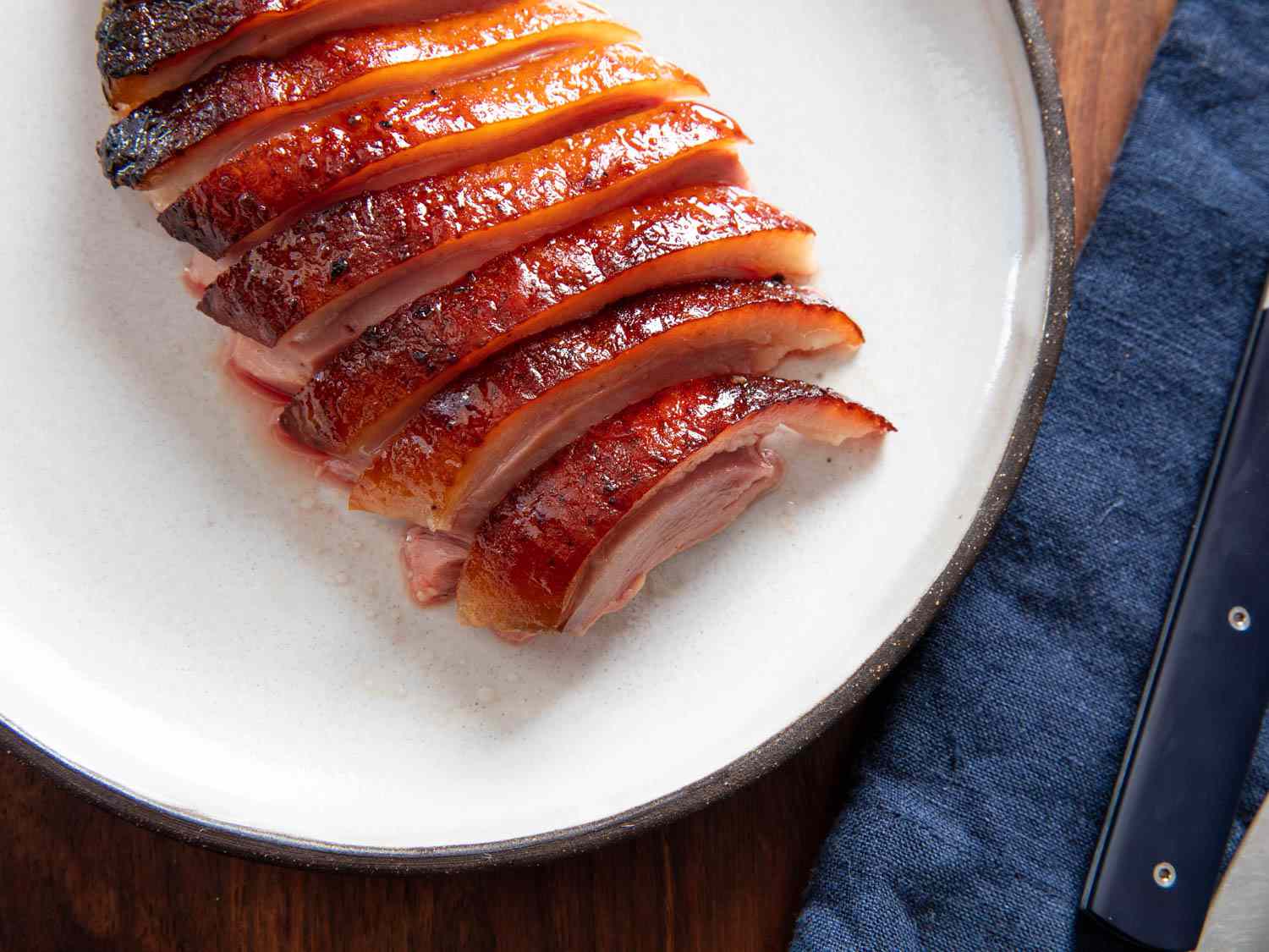 A plate of perfectly roasted duck breast with burnished skin.
