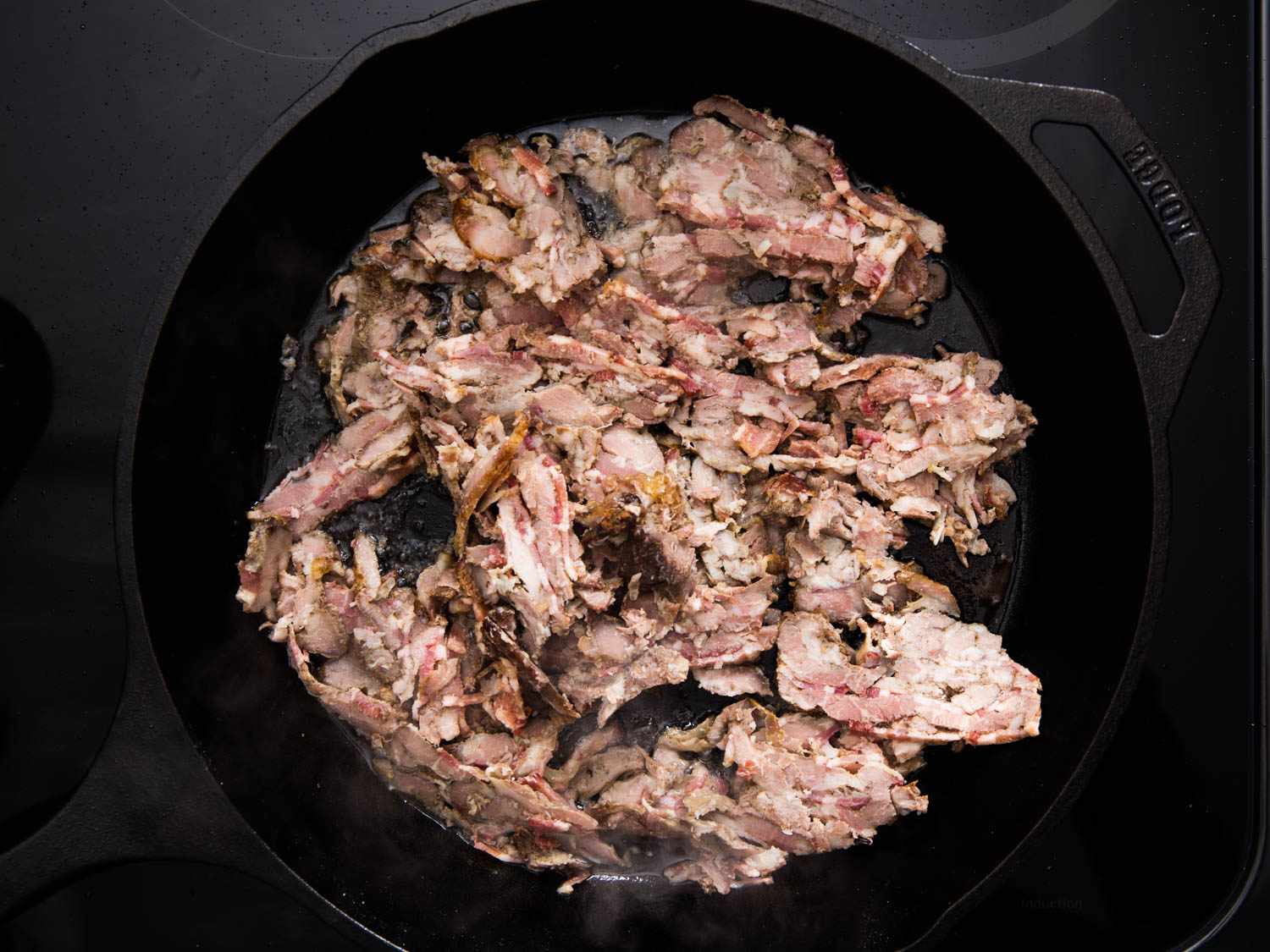 The sliced pork is fried in a cast iron skillet with reserved rendered fat.