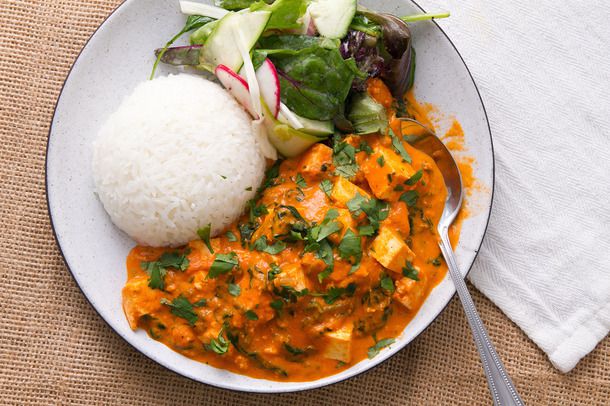 Butter paneer with spinach and rice on a plate.
