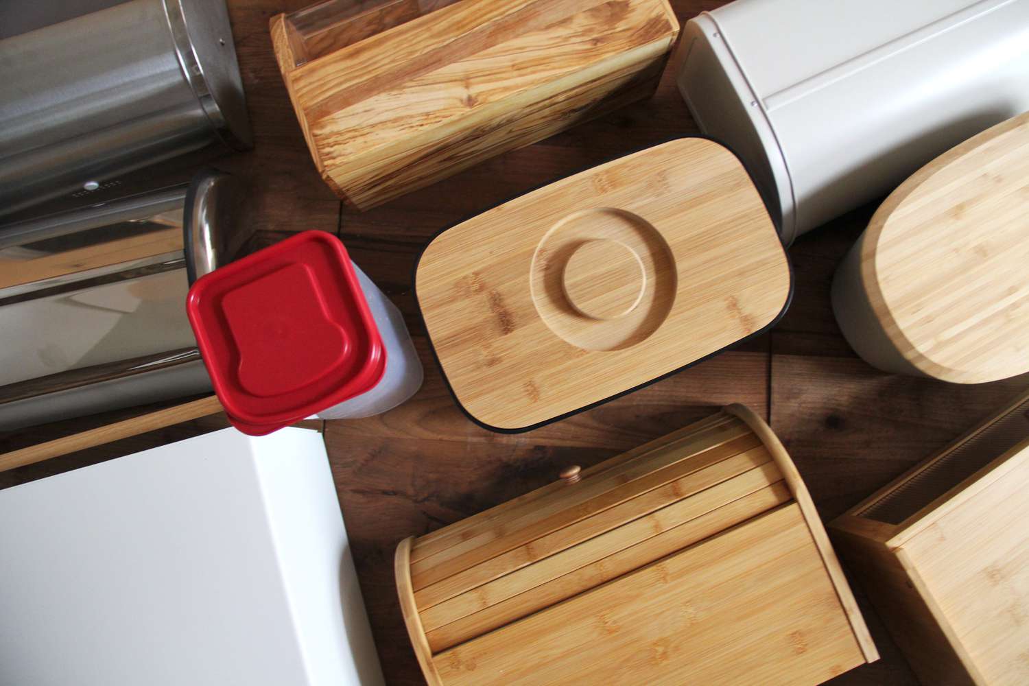 Numerous bread boxes on a wooden countertop.