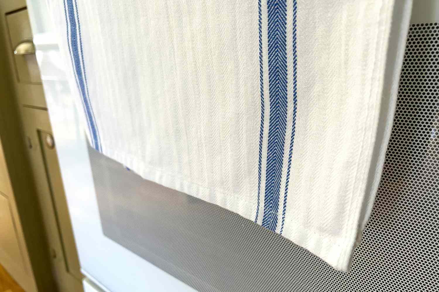 A kitchen towel hanging on an oven handle