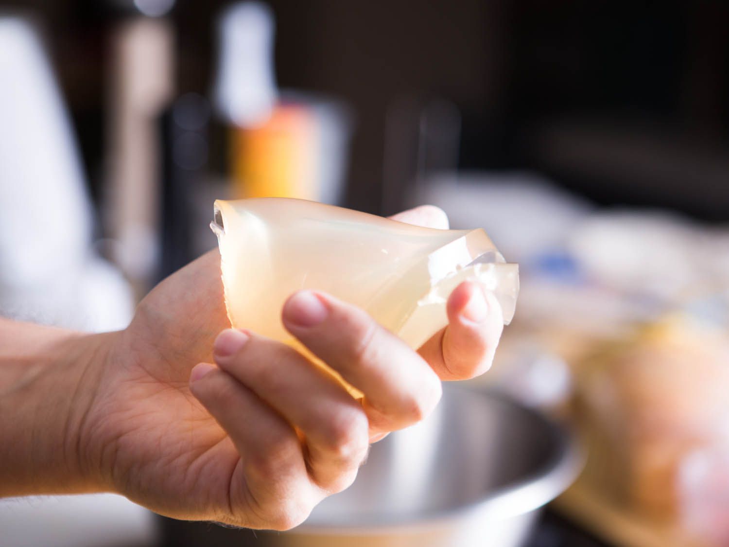 Hand holding firm gelled stock for meatballs.