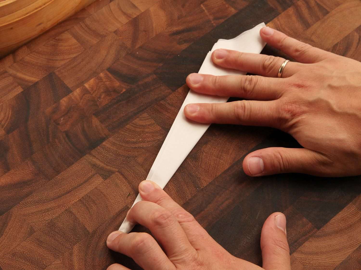 Folding sheet of parchment into a triangle.