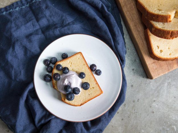 Overhead shot of slice of sour cream pound cake with blueberries and whipped cream