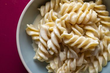 Closeup of pasta ai quattro formaggi, served in an eggshell-colored bowl.