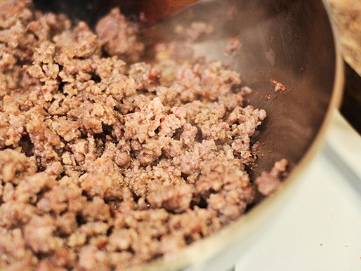 Breakfast sausage is broken up and browned in a saucepan.