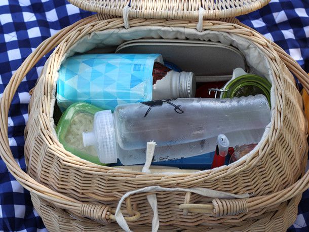 The inside of a picnic basket with water bottles being used to keep food cool.