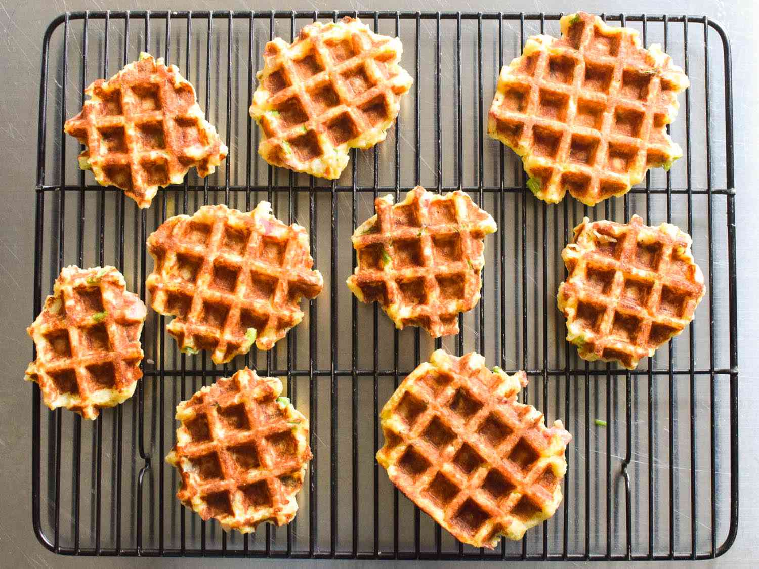 Waffled mashed potatoes resting on a wire rack. 