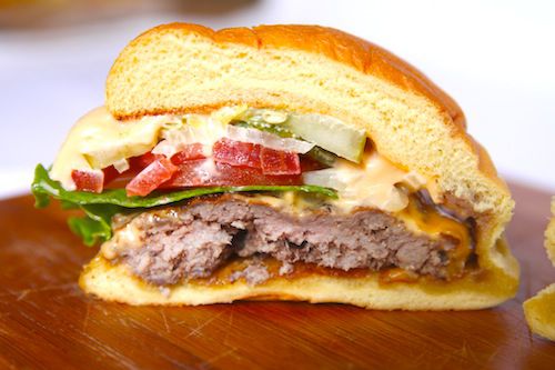 Closeup of a Shackburger that's been cut in half to reveal the patty cross-section and toppings.