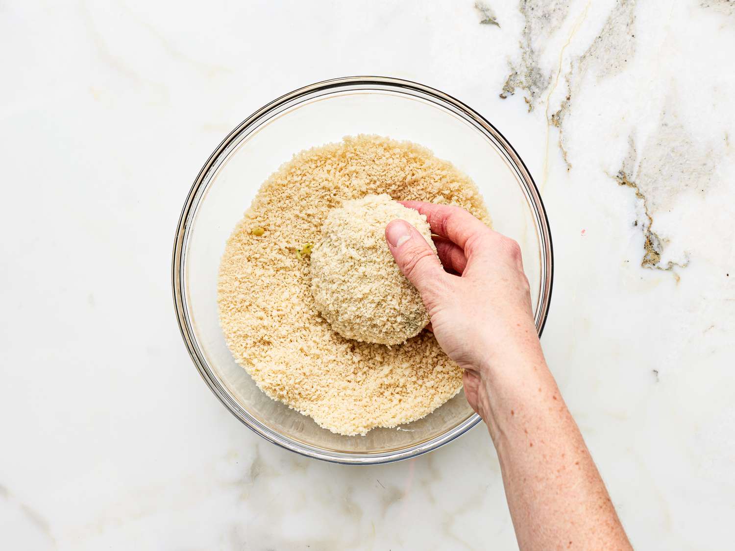 Dipping chickpea patties into breadcrumbs