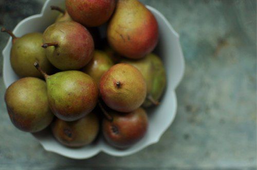 Overhead of bowl filled with green and red seckel pears