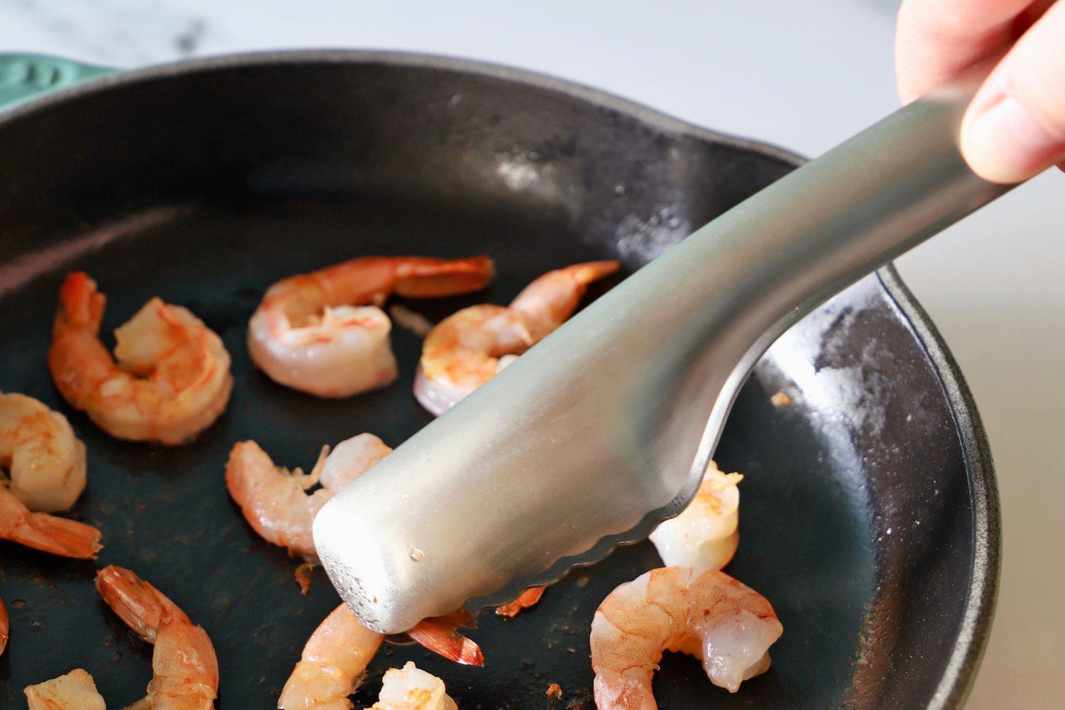 Hand using the Material Kitchen The Only Tongs to pick up a shrimp