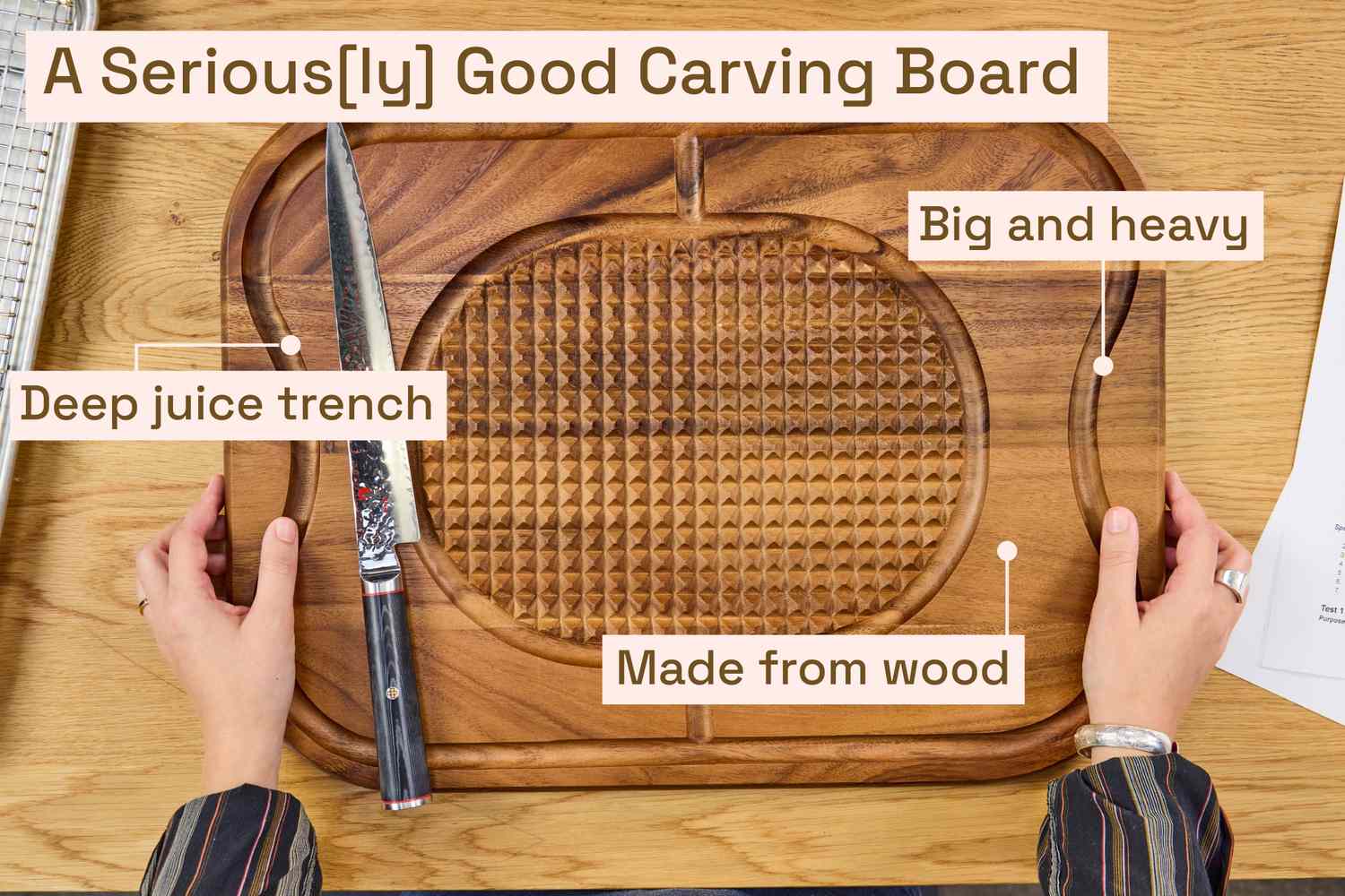 An overhead view of someone setting a wooden cutting board on a table