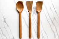 Field Company Cherry Wood Spoons & Spatulas on a white marble surface