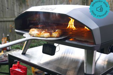 someone removing a pizza from the ooni koda 2 max