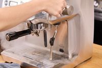 A person opens the steam valve on the Breville BES920XL Dual Boiler Espresso Machine