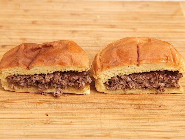 Two plain smashed hamburgers, cut in half to reveal the interior of their patties.