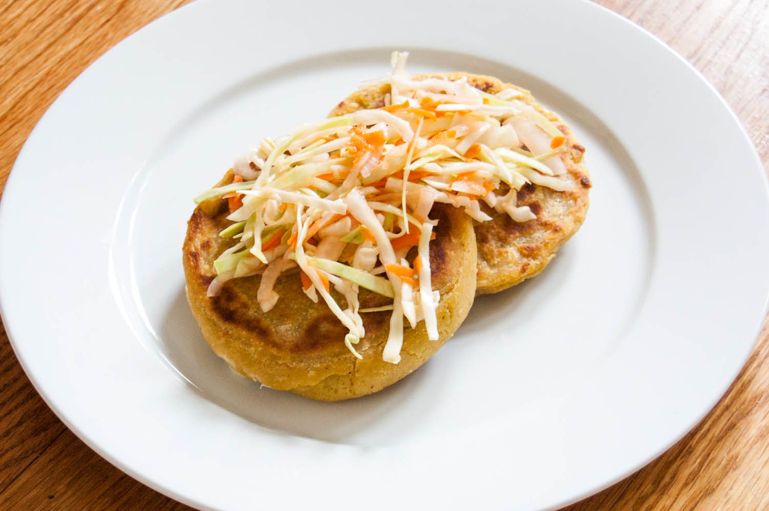 Two cheese and bean pupusas topped with cabbage slaw.