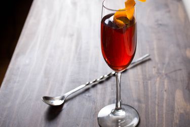 A Negroni Sbagliato cocktail in a fluted glass with a twist of orange peel