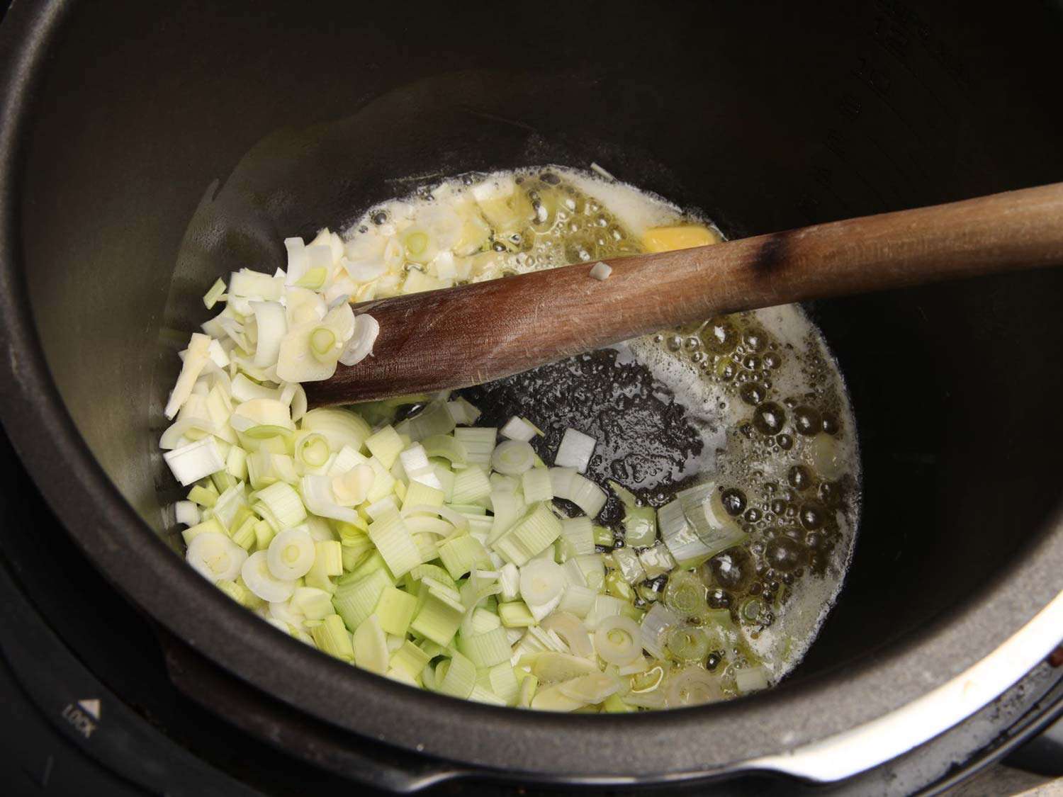 Cooking chopped leeks in butter in a pressure cooker.