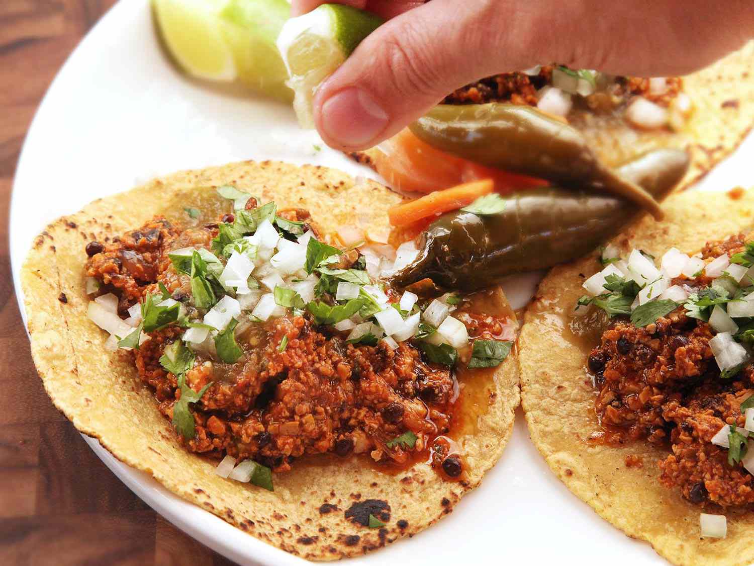 Author squeezing lime on a vegan chorizo taco.