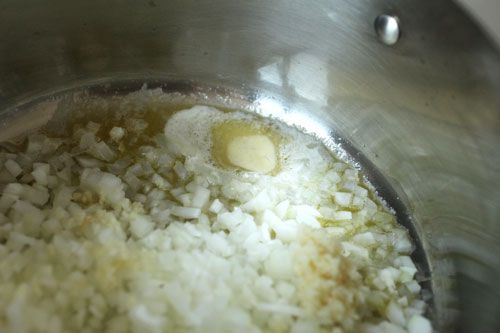 A saucepan of onions and garlic slowly cooking in butter.