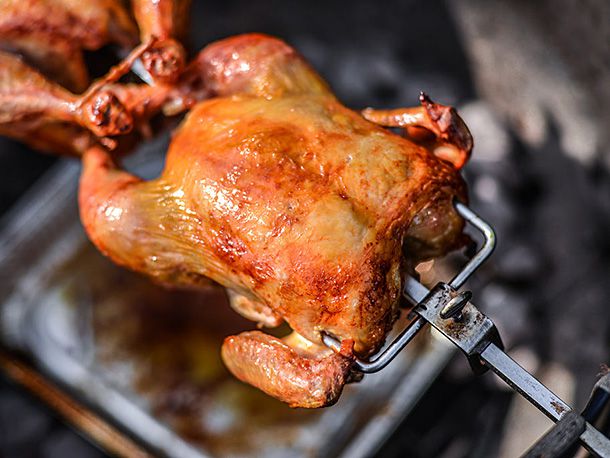 A rotisserie chicken rotating on a spit.