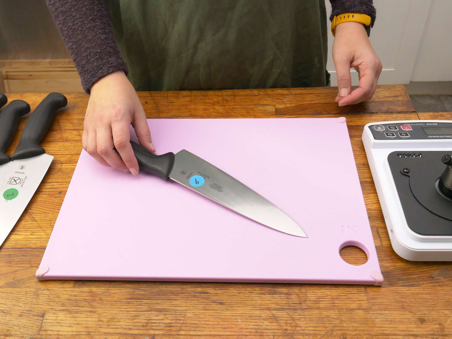 a person picking up a knife off a plastic cutting board