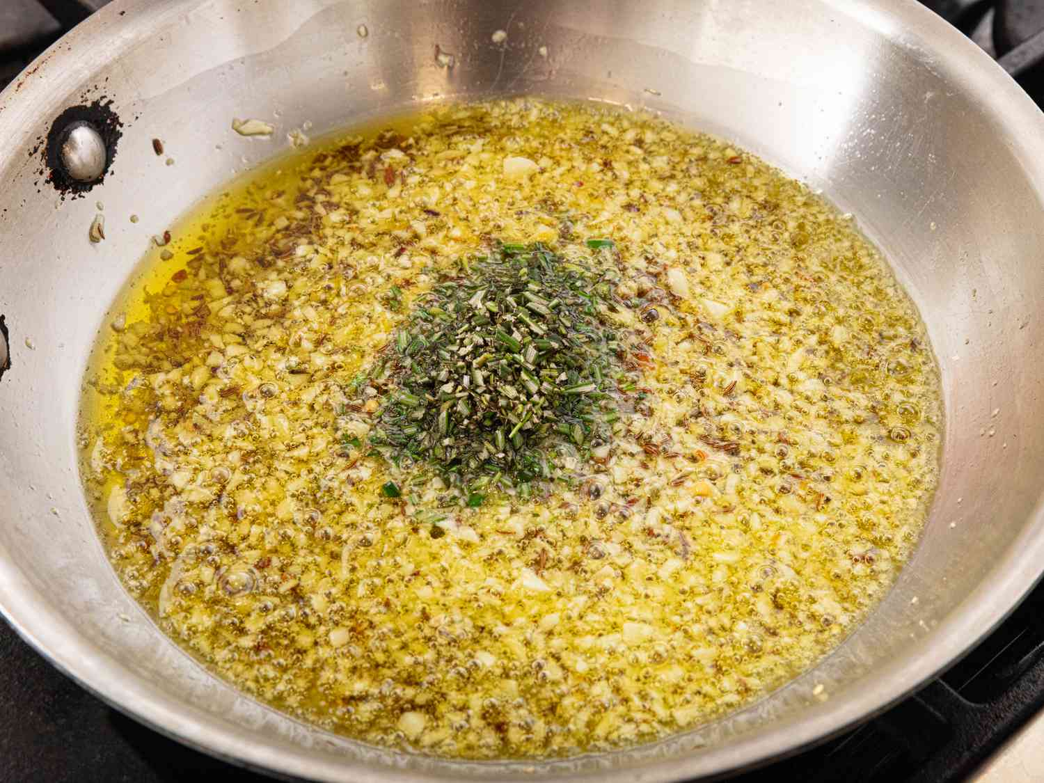 oil, lemon zest, caraway seeds and pepper flakes cooking in a pan