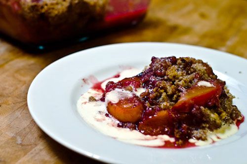 A piece of Bourbon Peach and Raspberry Crisp with cream
