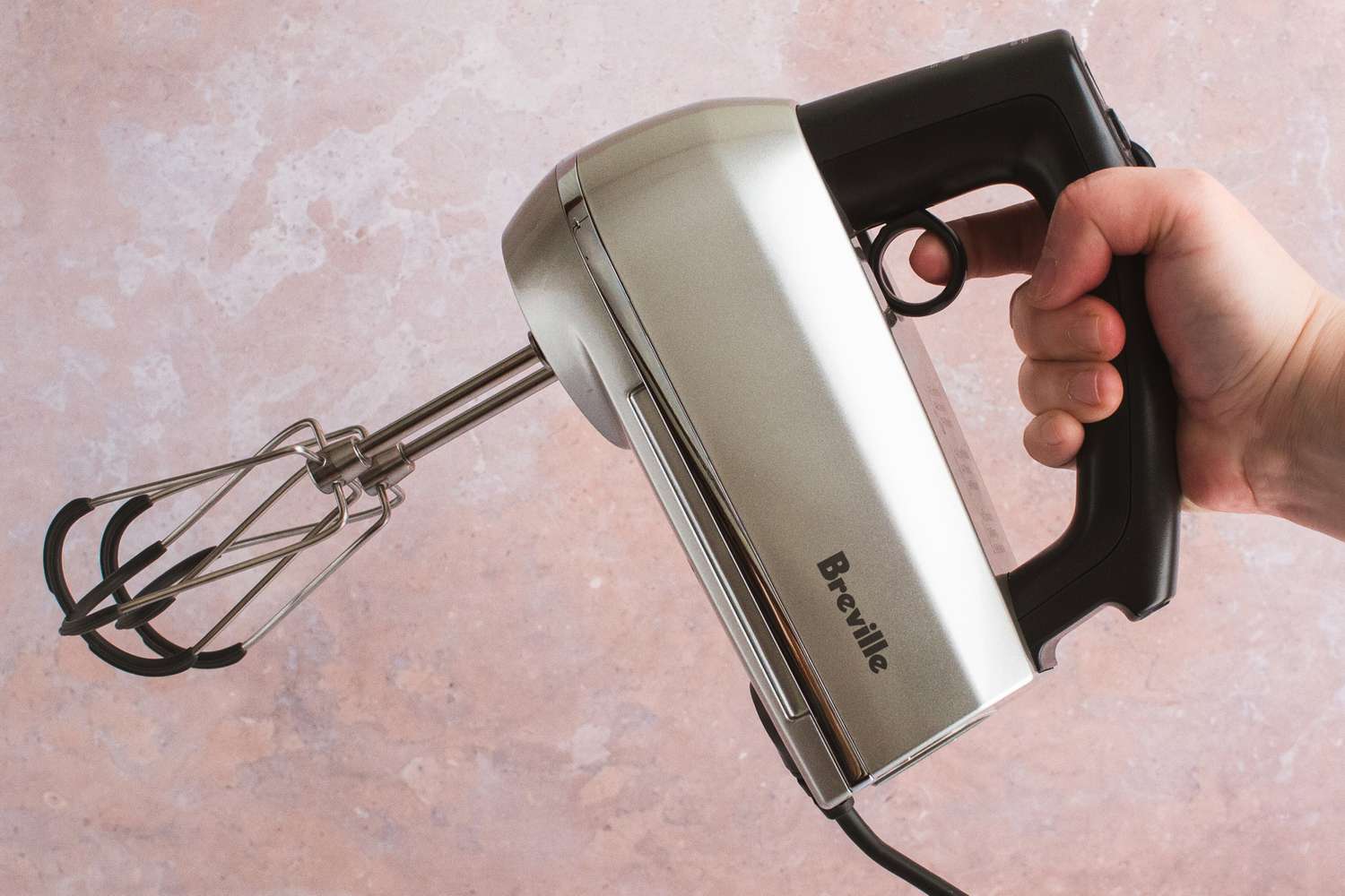 A person holding the Breville hand mixer.