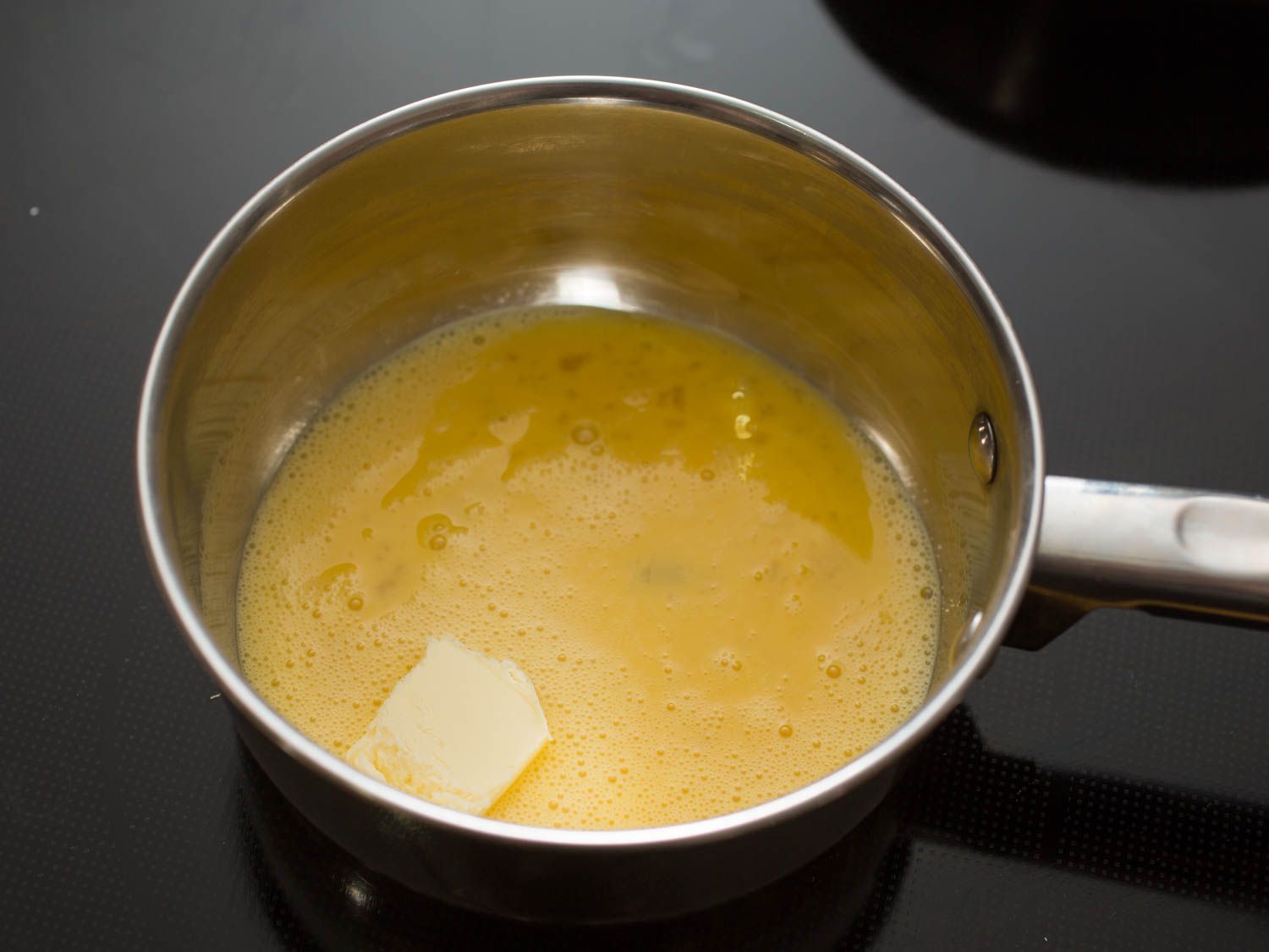 Starting eggs in a cold saucepan with a pat of butter.