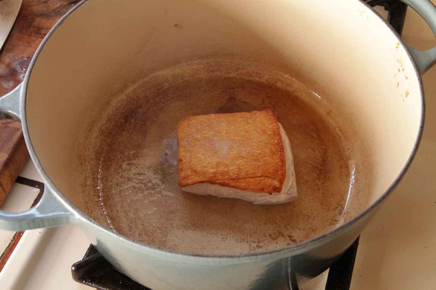 Browning pork belly in a Dutch oven for cassoulet. 