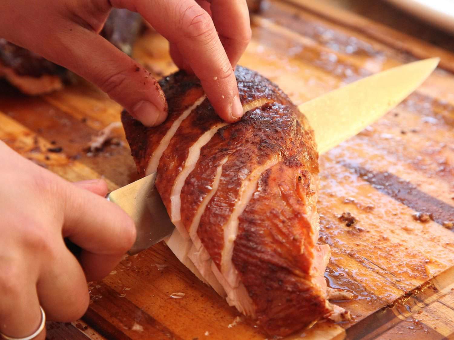 Slicing a smoked turkey breast.