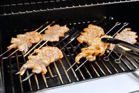 Shrimp skewers being cooked on a gas grill