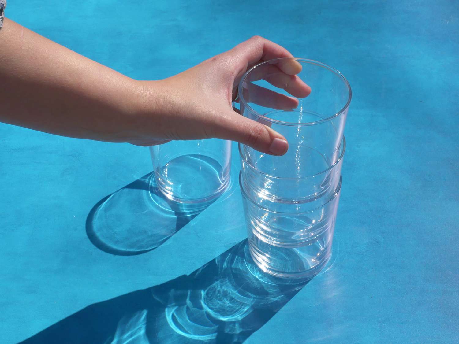 a hand stacking bormiolo rosso glasses