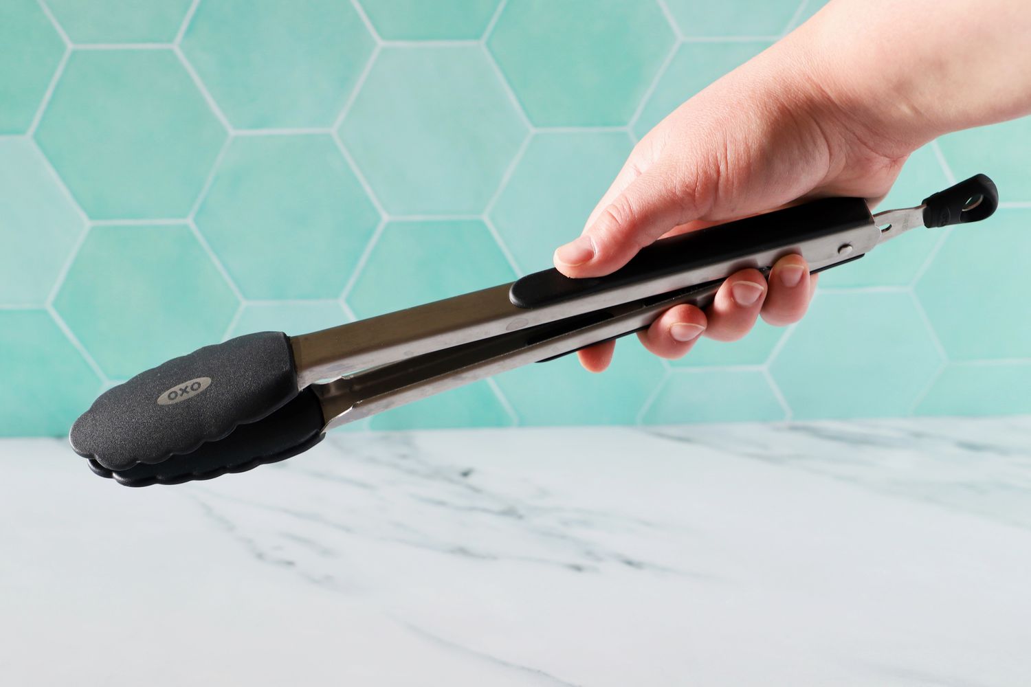 A person holding the OXO 12-Inch Silicone Tongs