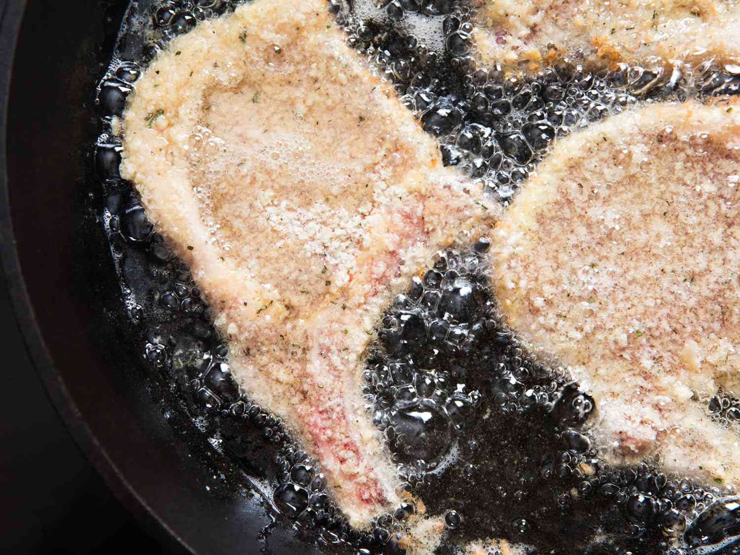 Frying breaded pork chops.