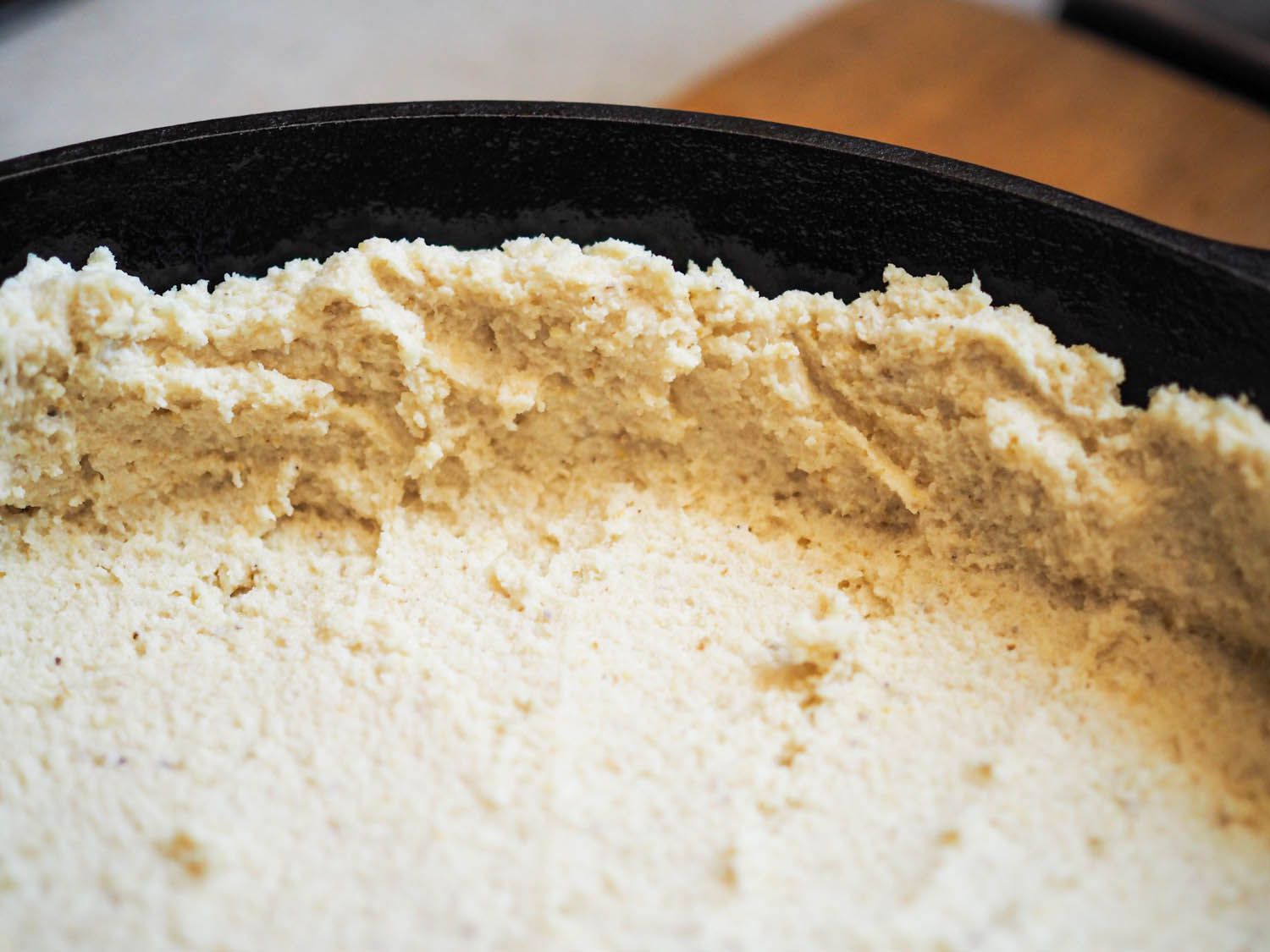 Close-up of the masa dough pressed into the corners of the skillet.