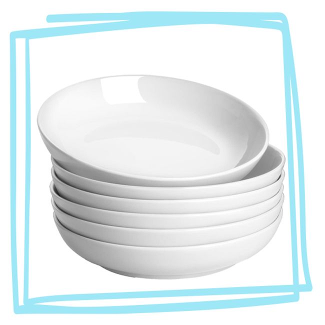 Stack of white pasta bowls on a plain background