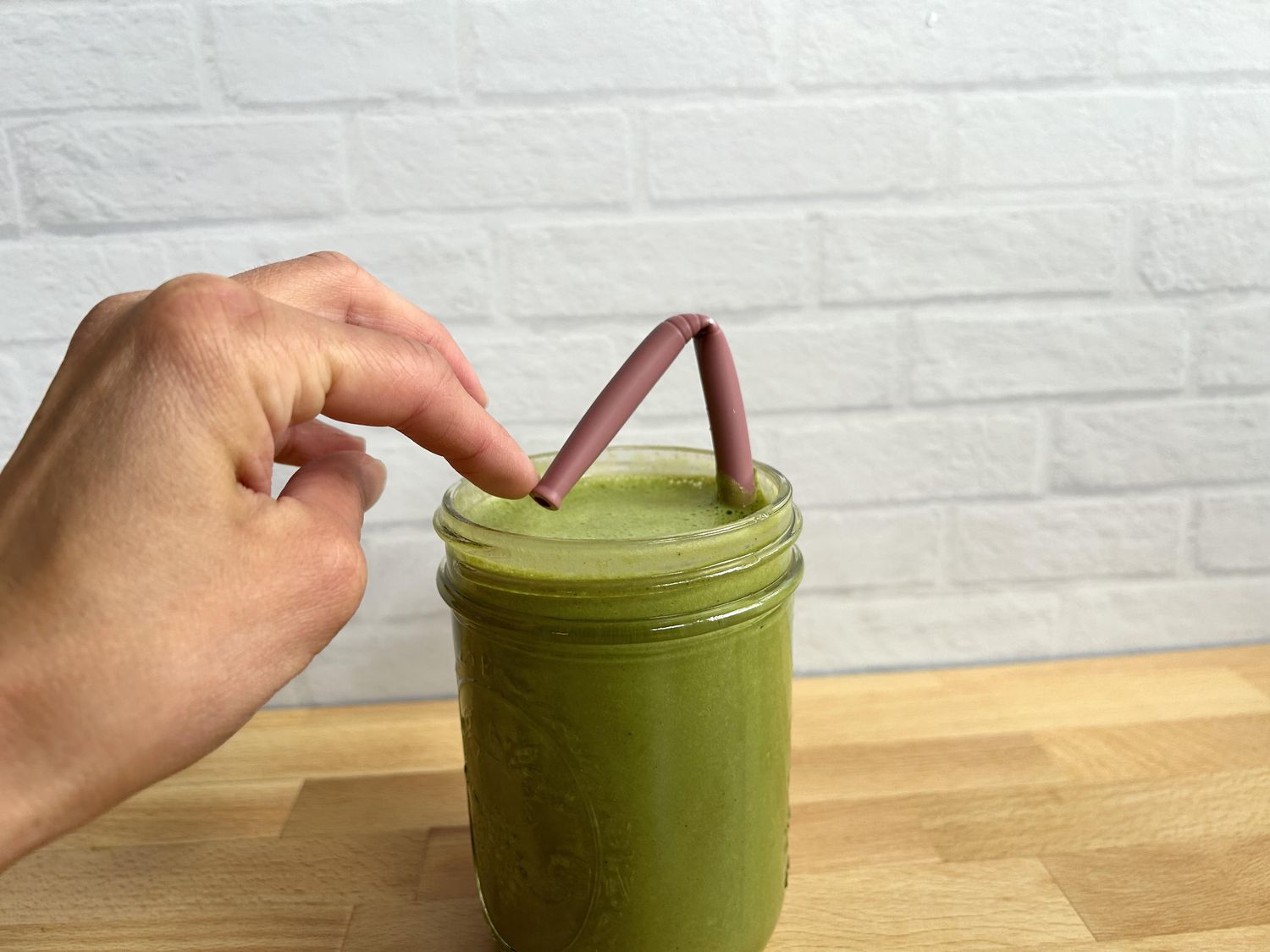 A hand bending a silicone reusable straw