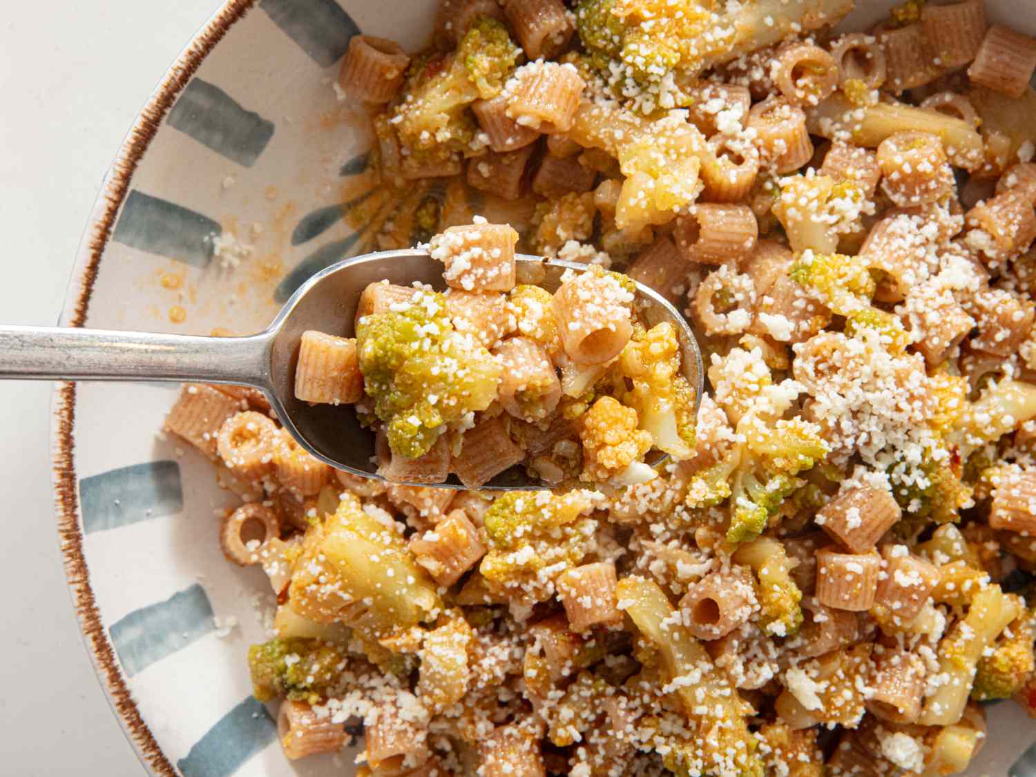 Pasta with Romanesco broccoli and cheese served on a plate with a spoon