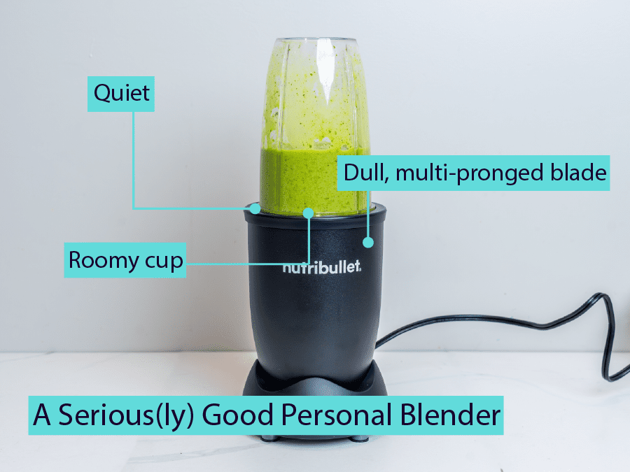 A personal blender blending a green smoothie.