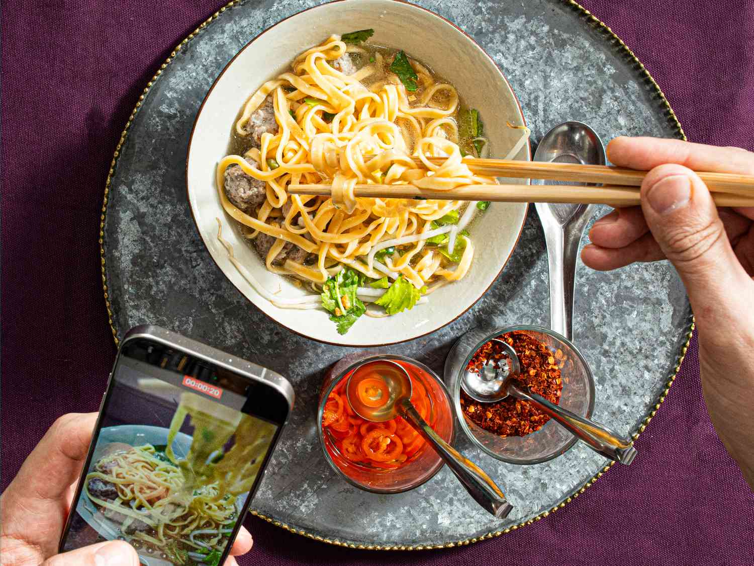 Overhead view of someone eating soup and taking a video