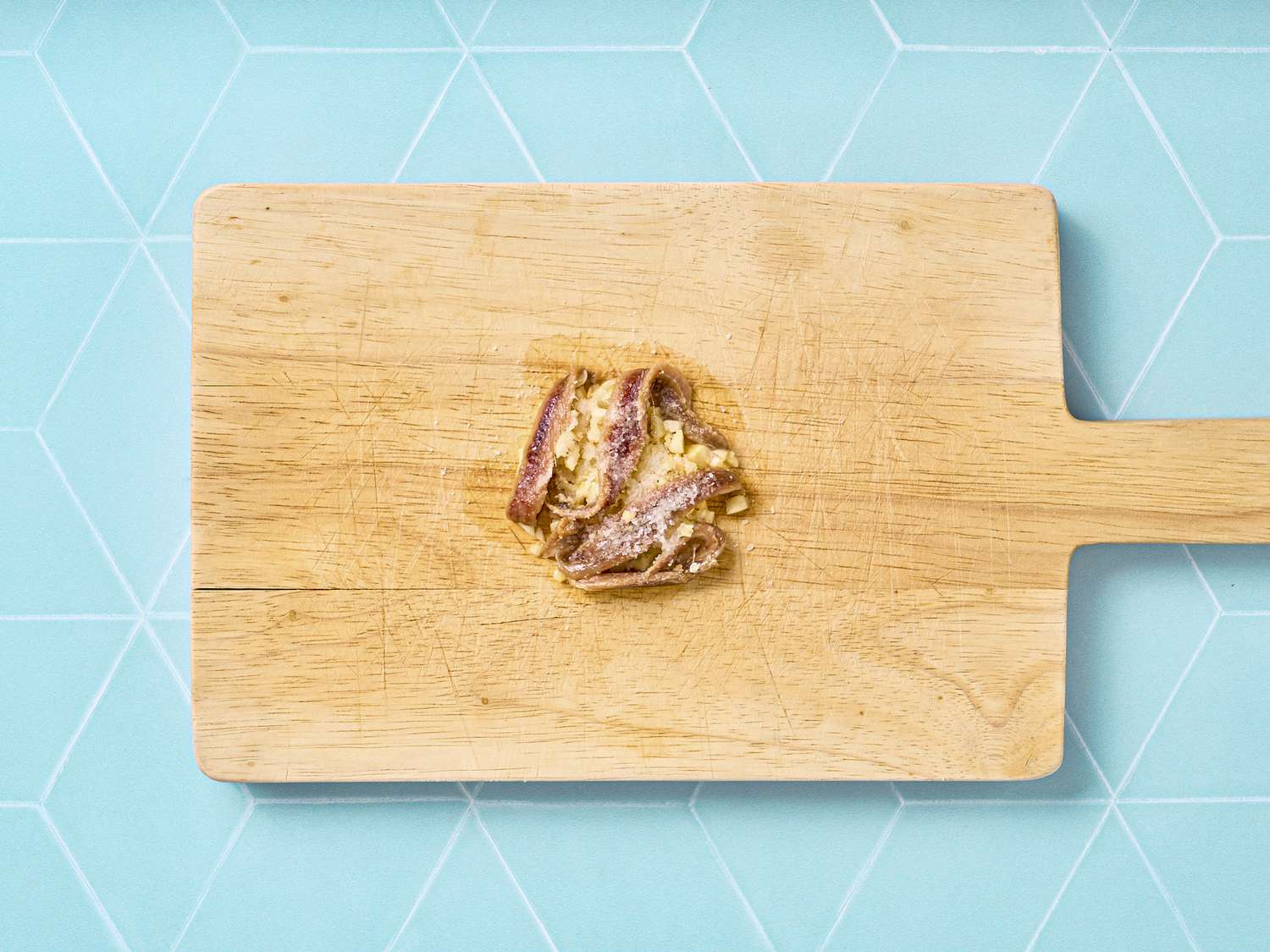 Achovies and garlic on cutting board