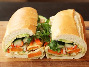 A cross-section view of bahn mi-style vegan sweet potato and avocado sandwich split into two halves